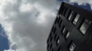 Yüksek katlı bir apartmanın dış cephesi, pencereleri ve balkonları.