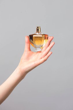 Parfüm şişesi Gri arka planda güzel kadın elleri