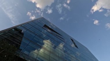 Yüksek katlı apartman cephesinin üstünde bulutlar dolaşıyor. Zaman aşımı