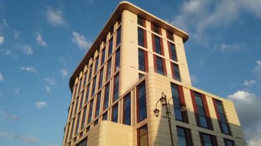 Yüksek katlı apartman cephesinde bulutlar dolaşıyor.