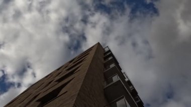 Binanın ön cephesinde, pencerelerde bulutlar uçuşuyor. Zaman Uygulaması