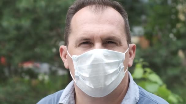 Man Bakgrunden Gröna Blad Bär Medicinsk Ansiktsmask Som Skyddar Mot — Stockvideo