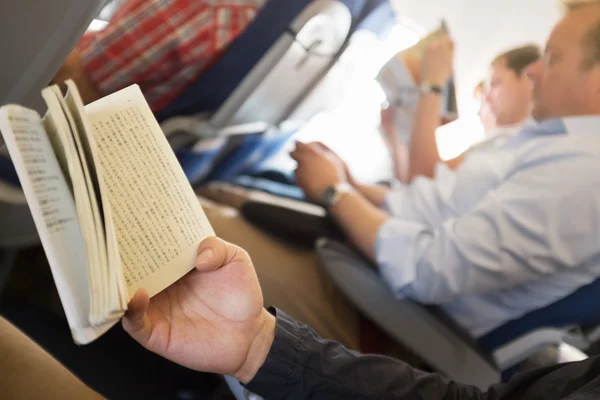 Läsa böcker i flygplan. — Stockfoto