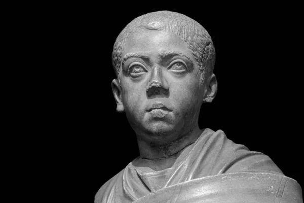 Boy in toga. Head of roman boy statue. Ancient sculpture isolated on black background. Classic antiquity young man man portrait