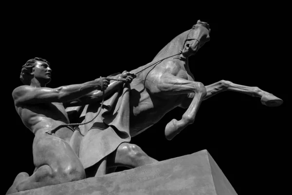 Cavallo e uomo scultura antica del ponte di Anichkov a San Pietroburgo. Monumento isolato su sfondo nero — Foto Stock