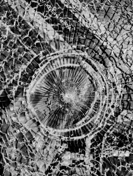 Vidrios rotos. Agujero redondo con grietas radiales en el vidrio. Grietas redondas blancas en vidrio sobre fondo negro —  Fotos de Stock