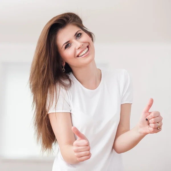 Joyful young woman in t-shirt showing thumbs up. isolated on whi — Stock Photo, Image