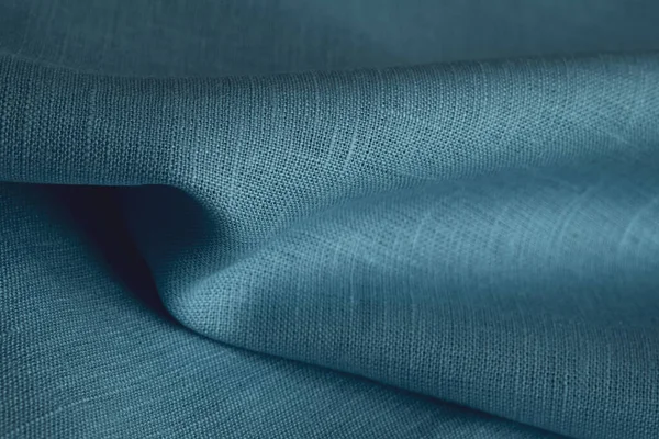 Linen fabric, blue background. Soft linen blue fabric texture. Textured fabric background. Macro with shallow dof