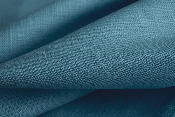 Linen fabric, blue background. Soft linen blue fabric texture. Textured fabric background. Macro with shallow dof