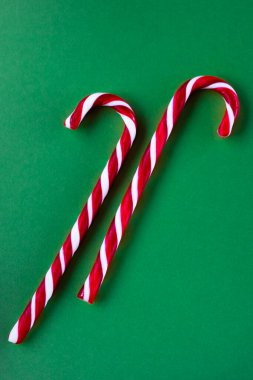 Yeşil arka planda kırmızı ve beyaz Noel şekerleri. Noel konsepti. Düz konum, üst görünüm, kopyalama alanı