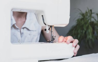 Evinde çalışırken dikiş diken bir kadın. Dikiş işlemi - Dikiş arkasında kadın elleri