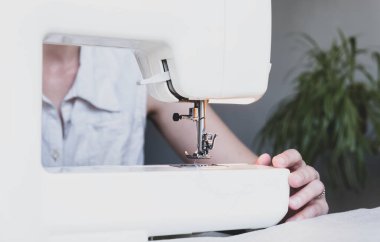 Evinde çalışırken dikiş diken bir kadın. Dikiş işlemi - Dikiş arkasında kadın elleri