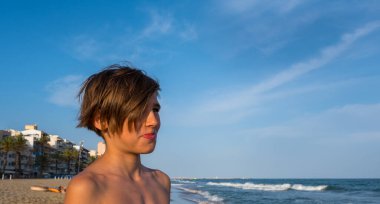 Mavi gökyüzü ve Akdeniz 'in arka planında gülümseyen sevimli bir çocuğun portresi