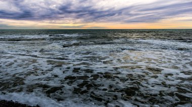 Sprey ve köpükle kıyıya yakın deniz dalgası. Dalgalar körfez kıyılarına vuruyor