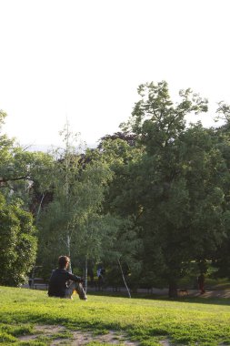 Prag, Çek Cumhuriyeti - 5 Haziran 2009: Riegrovy sady 'de çimlerde oturan ve güneşli yaz akşamlarının tadını çıkaran insanlar. Prag tarihi şehri gözcüsü