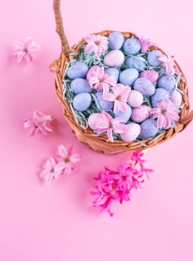 Mutlu Paskalyalar. Çukulatalı yumurta ve bahar çiçekli hasır sepet, seçici odak. Paskalya kutlaması için gebelik kartı, kopyalama alanı