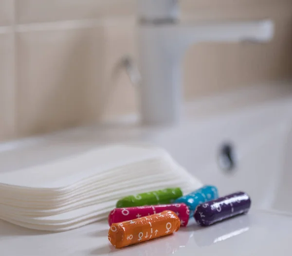 Female sanitary pads and medical female tampons on the bathroom table. Feminine hygiene products