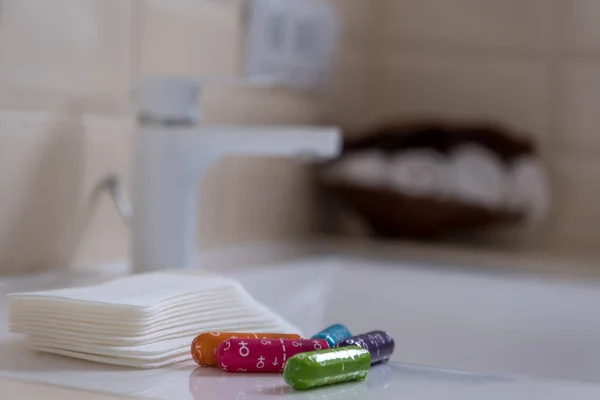 Female sanitary pads and medical female tampons on the bathroom table. Feminine hygiene products