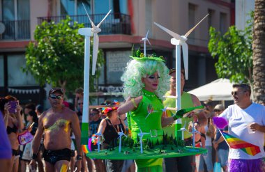 Sitges, Katalonya, İspanya - 11 Haziran 2017: Katılımcı Gay Pride Sitges rüzgar jeneratörlü yeşil kostüm giydi. Rüzgar jeneratörlü harika bir manzara. Alternatif elektrik kaynakları, sürdürülebilir kaynaklar kavramı. 