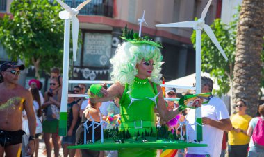 Sitges, İspanya - 11 Haziran 2017: Katılımcı Gay Pride rüzgar jeneratörlü yeşil kostüm giydi. Rüzgar jeneratörlü harika bir manzara. Gelecekteki temiz alternatif enerji kavramı