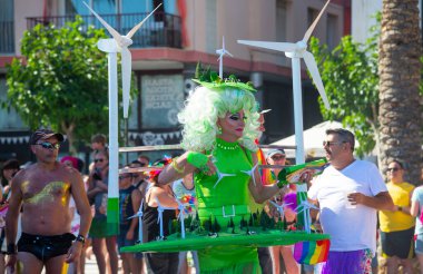 Sitges, Katalonya, İspanya - 11 Haziran 2017: Katılımcı Gay Pride Sitges rüzgar jeneratörlü yeşil kostüm giydi. Rüzgar jeneratörlü harika bir manzara. Alternatif elektrik kaynakları, sürdürülebilir kaynaklar kavramı. 