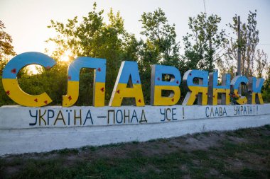 Stella, Slavyansk girişinde. Şehirdeki düşmanlıkların sona ermesinden sonra gönüllü eylemciler standı sarıya ve maviye boyadı ve kabuk ve mermi izlerini, çeliği süsleyen gelinciklerin çekirdeklerine dönüştürdü.