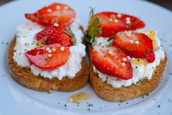 Çilekli sağlıklı tost, süzme peynir ve bal. Lezzetli bir kahvaltı. Temiz yemek, diyet ya da vejetaryen için sağlıklı sandviç tarifi. Yaz sabahı, kahvaltı ya da atıştırmalık. Yaz iştah açıcı