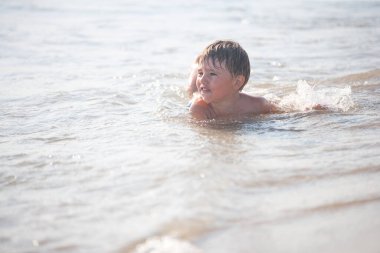 Sahilde küçük bir çocuk, seçici bir odak noktası. Yaz zamanı. Rahatlama ve sağlıklı yaşam tarzı kavramı