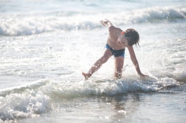 Sahilde küçük bir çocuk, seçici bir odak noktası. Yaz zamanı. Rahatlama ve sağlıklı yaşam tarzı kavramı