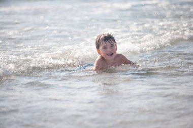 Sahilde küçük bir çocuk, seçici bir odak noktası. Yaz zamanı. Rahatlama ve sağlıklı yaşam tarzı kavramı