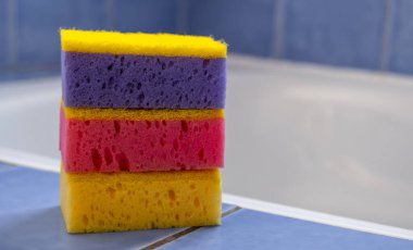 Banyodaki süngerler. - Yakın çekim. Ev temizliği için renkli aksesuarlar. Temiz ev. Ön görünüm.