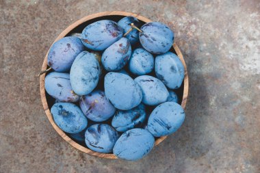 Tahta bir kasede olgun erikler. Evde bahçe ve hasat kavramı.