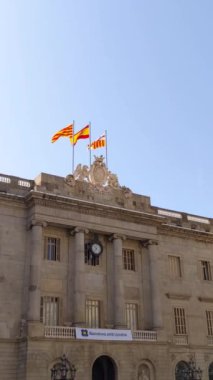 Barselona, Katalonya ve İspanya 'nın bayrakları, Barcelona şehir meclisinin tepesinde rüzgarda dalgalanıyor. Barselona Avrupa 'nın popüler bir turizm beldesidir.