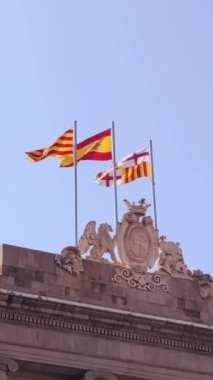 Barselona, Katalonya ve İspanya 'nın bayrakları, Barcelona şehir meclisinin tepesinde rüzgarda dalgalanıyor. Barselona Avrupa 'nın popüler bir turizm beldesidir.