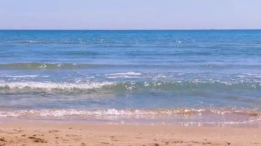 Sea water waves on sandy beach.