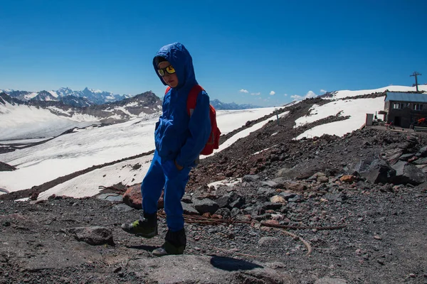 Little boy on the background of the mountains, family holidays, hiking, determination, courage, self-realization. International Mountaineering Day - 8 August. International Mountain Day - 11 December