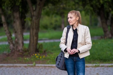Outdoors portrait of a beautiful young girl looking away while waiting for someone