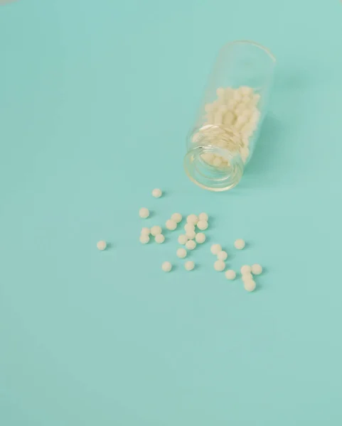 Альтернативная Концепция Гомеопатии Гомеопатические Глобулы Разбросанные Прозрачной Стеклянной Бутылке Голубом — стоковое фото
