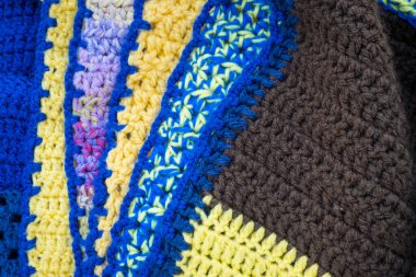 Hand-crocheted plaid. Geometric seamless knitted pattern. The texture is crocheted. Knitted blue background. Crochet. Knitted background