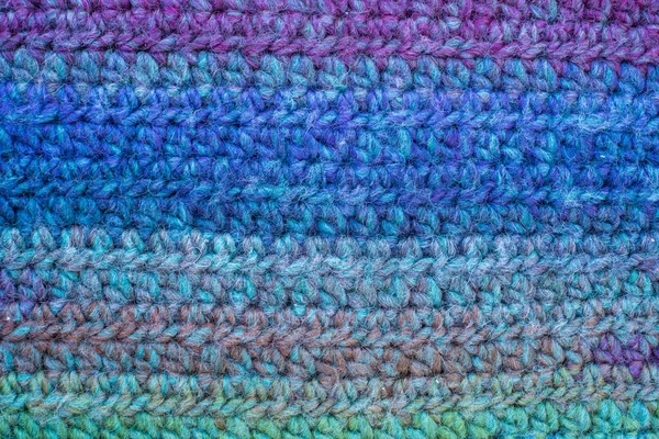 Hand-crocheted plaid. Geometric seamless knitted pattern. The texture is crocheted. Knitted blue background. Crochet. Knitted background