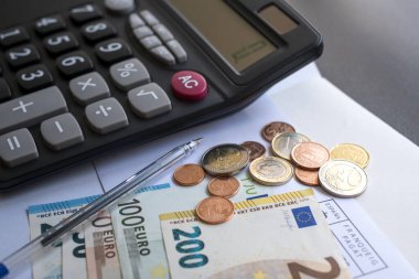 Calculator, money, pen and envelope on the table. Counting money, utility bills, payment for gas and electricity. Pension calculation