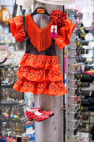 Traditional flamenco dress with dance shoes in store