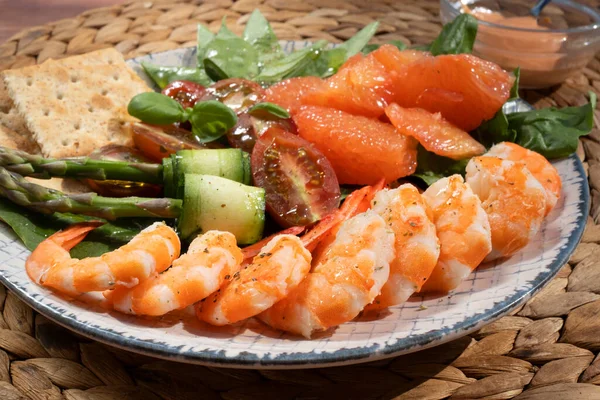 A healthy green garden salad with cooked shrimp