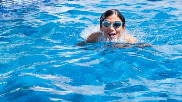 Cute boy in a swimming pool. Sport activities for children, outdoor swimming lessons. Summer vacation at the hotel. Outdoor swimming pool. Healthy lifestyle concept