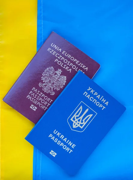 Ukrainian and Polish biometric passport on background of the national flag of Ukraine.International travel document.Marriages between foreigners.Poland's help to Ukrainian citizens.Support for Ukraine