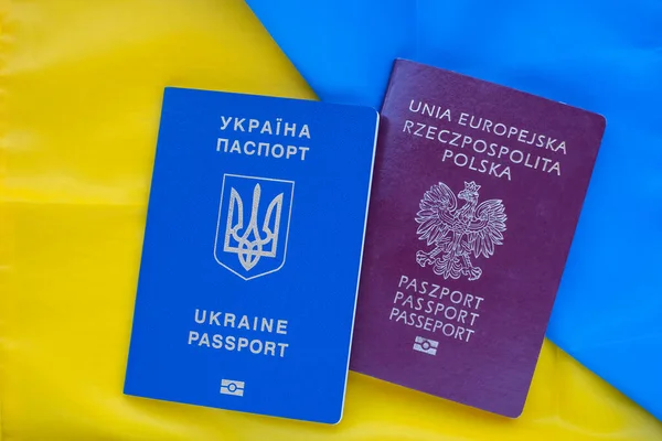 Polish and Ukrainian biometric passport on background of the national flag of Ukraine.International travel document.Marriages between foreigners.Poland's help to Ukrainian citizens.Support for Ukraine