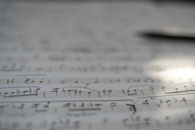 Müzikal notaların arkaplanı: Piyano için skor, yakın çekim. Notaları ve kalemi olan bir çarşaf. Konservatuar, müzik, notalar, müzik dersleri, sanatsal yaşam konsepti