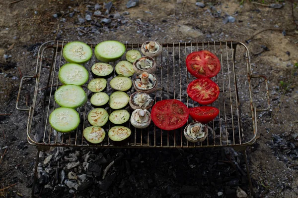 Vegetables on a campfire barbecue while camping outdoors. Outdoor recreation. Food cooked over a campfire