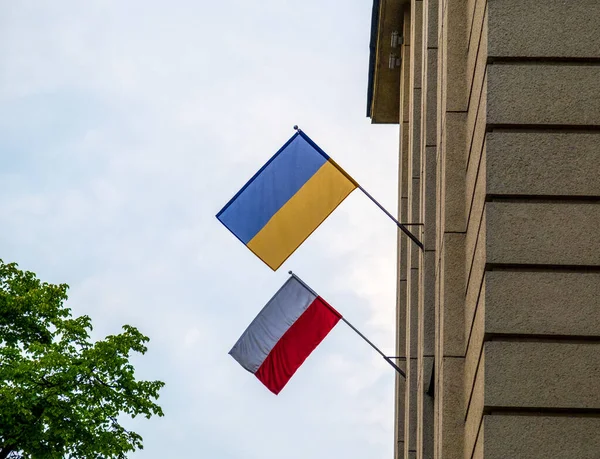 The flag of Poland and Ukraine together on the facade of building. Its a symbol of opposition to Russian aggression, a sign of solidarity and help Ukraine. Copy space