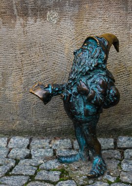 Wroclaw, Polonya - 27 Eylül 2019: 'Turysta' - Sırt çantalı ve haritalı Cüce. Cüce, cüce, Wroclaw 'daki ünlü küçük heykeller.